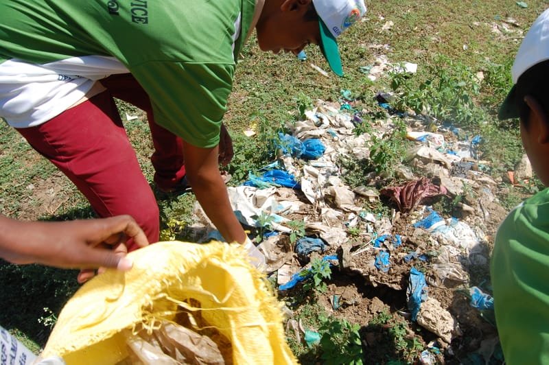 Volunteer brigade collecting plastic debris along the riverbank.